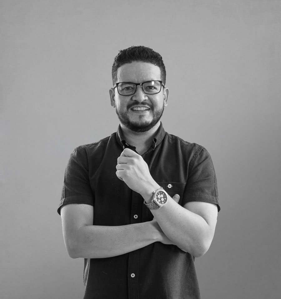 Retrato de Mag Jaramillo, brazos cruzados, ciudad de fondo